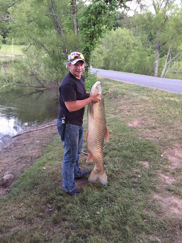 HIGH SCHOOL STUDENT CATCHES A FOUR-FOOT-LONG FISH AT RURAL RETREAT LAKE